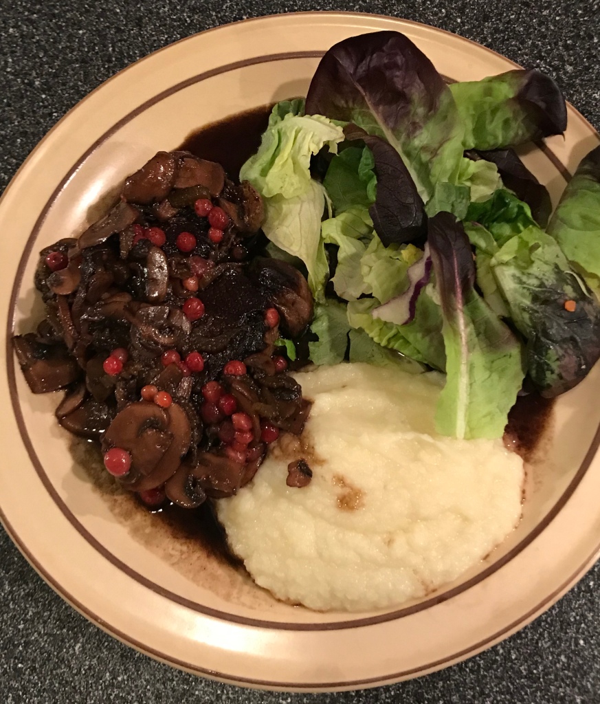 Steak with mushroom-huckleberry sauce, green salad, and mashed cabbage.
